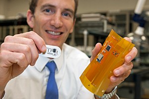 UC researcher Jason Heikenfeld is holding next generation of sweat sensor pad and flexible bluetooth circuit.