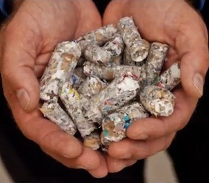 Close-up of hands holding fuel pellets made from waste paper.