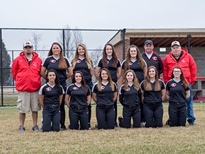 Softball team posing on field for team photo.