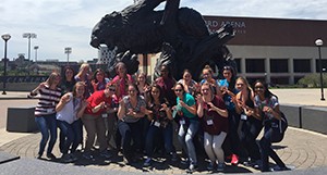 Excited 2016 Women in Engineering and Applied Science Summer Camp participants pose with the 15-foot tall, two-ton, bronze UC Bearcat statue near Fifth Third Arena and the Marge Schott Baseball Stadium.