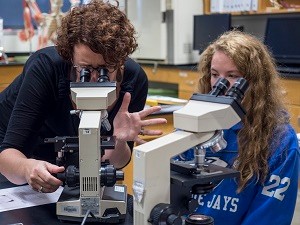 UC Clermont Professor Krista Clark (left) examines samples under the microscope with biology student McKinley Raines.  