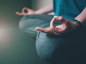 close up of hands while sitting and meditating