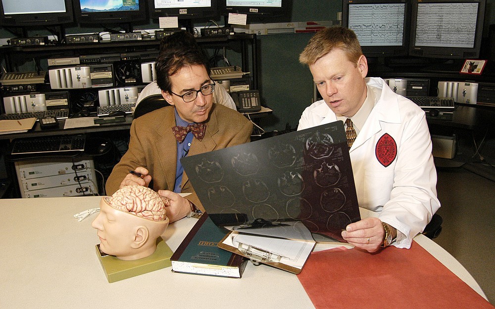 Epileptologists Michael Privitera, MD, left, and David Ficker, MD, discuss a patient in the monitoring unit of the Epilepsy Center at the University of Cincinnati Neuroscience Institute.