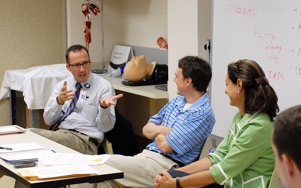 Jeffrey Schlaudecker, MD, assistant professor for the division of geriatrics, talks with students after their encounter with a standardized patient.
