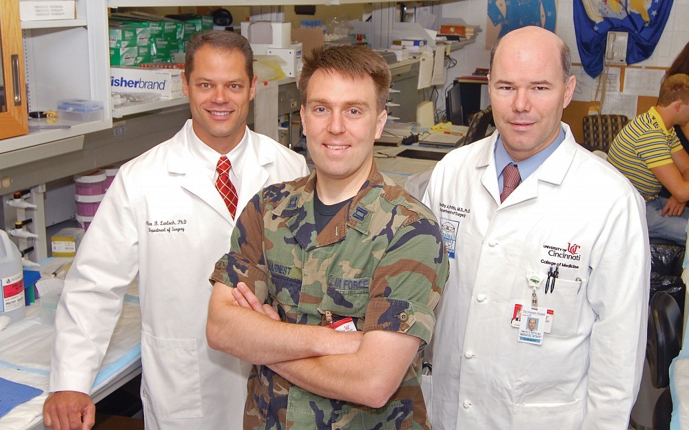 United States Air Force Capt. Ryan Earnest, MD (middle), will spend the year working on Air Force-funded research at UC with experts including Alex Lentsch, PhD (left), and Timothy Pritts, MD, PhD (right), as part of his surgical residency program.