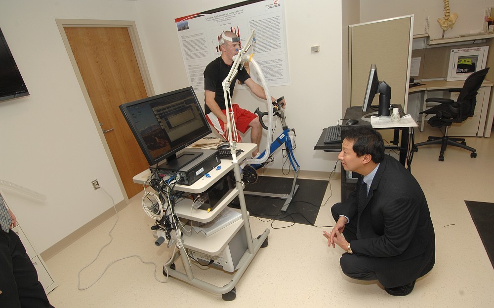 During his visit to the College of Allied Health Sciences, UC President Santa Ono, PhD, watched as rehabilitation sciences student Mark Gutteridge pedaled on a cycle ergometer (a stationary bicycle outfitted with an ergometer, or work measurement device).