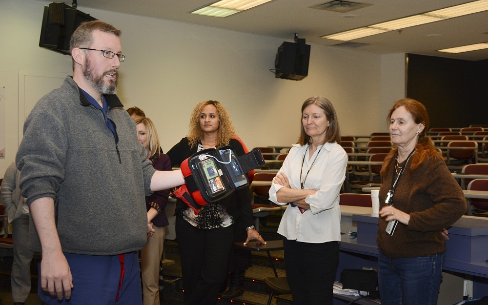 Jason McMullan, MD, associate professor in the Department of Emergency Medicine, leads a training session for using automated external defibrillators installed in the Medical Sciences Building.