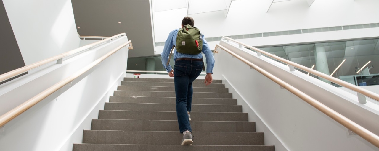 Student walking up stairs in Lindner College of Business